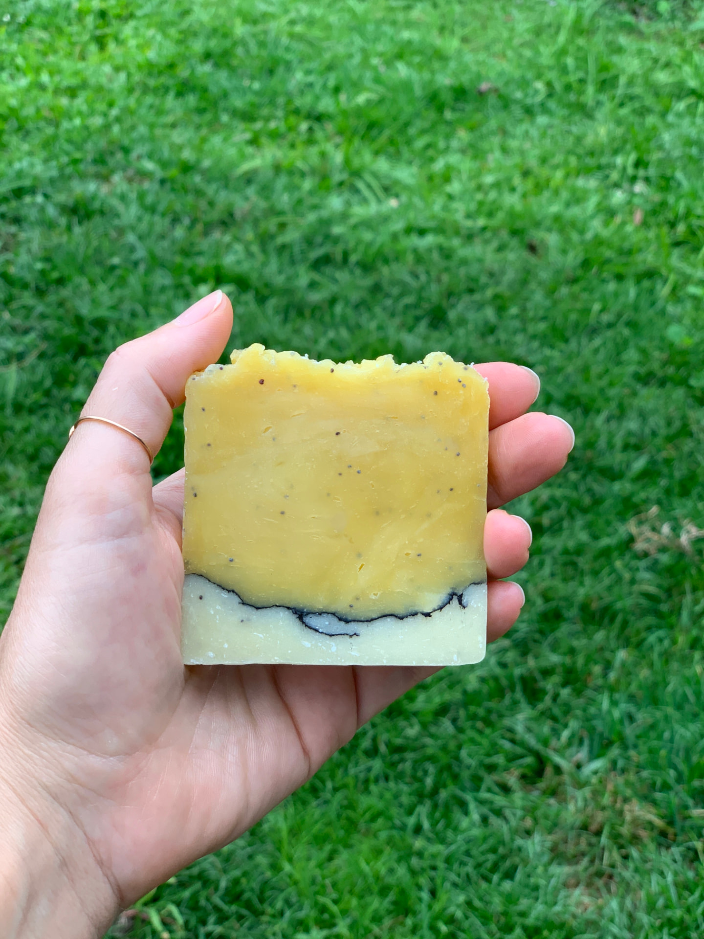 Sabonete natural de calêndula e papoula segurado na mão